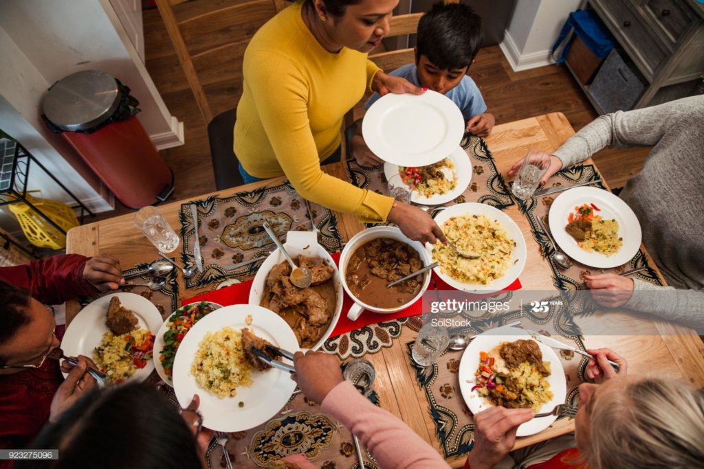 A woman serving her family Pualo( mixed veg/ non veg rice) for Iftaar for the festival  of Ramzan