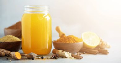 Ingredients for orange turmeric drink on grey concrete background. Lemon water with ginger, curcuma, black pepper. Vegan hot drink concept. For PCOS and Healthy Living
