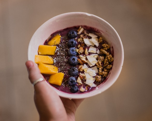 Healthy Oats Bowl with layered fruits, nuts and coconut 